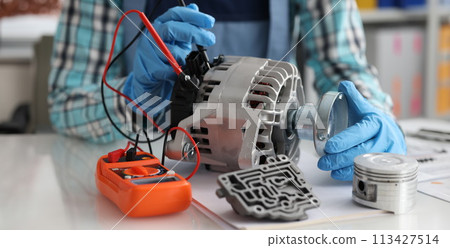 Automotive alternator repair test stator closeup with copper coil in workshop Automotive alternator repair test stator closeup with copper coil in workshop 113427514