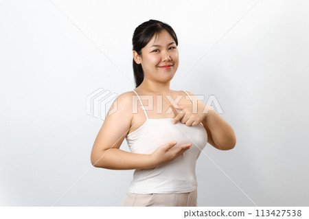 Asian woman checking lumps on her breast for signs of breast cancer on white background. 113427538