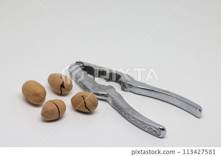 Pecan nuts and nutcracker, healthy product, healthy food. Pecan nuts and nutcracker, healthy product, healthy food. 113427581