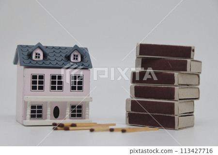 Matches and matchboxes next to a toy house on a light background. Real estate insurance concept. 113427716