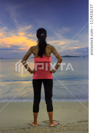 Woman standing on the beach 113428237