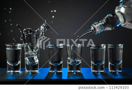 Barman pouring hard spirit into glasses. Barman pouring hard spirit into glasses. 113429103