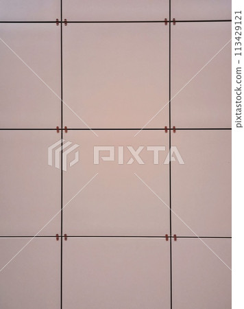 Texture, pattern, background of square panels of orange-pink coral-salmon color, frontally mounted on the wall 113429121
