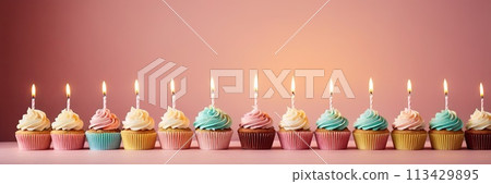 Colorful cupcakes with lit candles are displayed against a pink background, indicating an indoor celebration event marking of joy and celebrating. with free space Colorful cupcakes with lit candles are displayed against a pink background, indicating an indoor celebration event marking of joy and celebrating. with free space 113429895