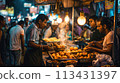 Mumbai. Crowd gathers as vendor prepares vada pav on busy Mumbai street 113431397