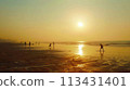 Mumbai. Juhu Beach at dawn: joggers, yoga, vast sand, rising sun in serene setting 113431401