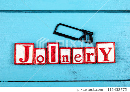 JOINERY. Miniature saw on a blue wooden background. construction and carpentry concept JOINERY. Miniature saw on a blue wooden background. construction and carpentry concept 113432775