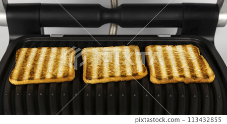 Cooking toasted bread on an electric grill. Toast bread concept. 113432855