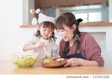 Girl and mother preparing dinner 113433166