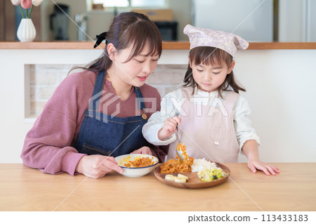Girl and mother preparing dinner 113433183