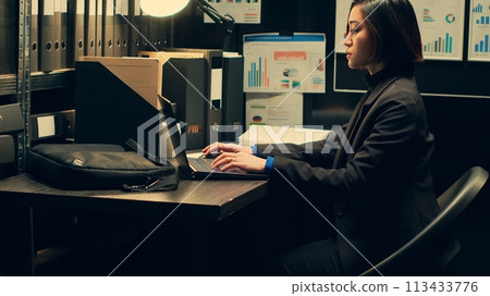 Law agent studying criminal case files and statements, working on uncovering new clues in archive room. Private investigator looking into suspects background checks, criminology. Camera A. Law agent studying criminal case files and statements, working on uncovering new clues in archive room. Private investigator looking into suspects background checks, criminology. Camera A. 113433776