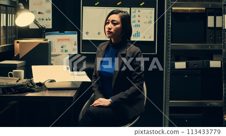 Detective looks at holographic images captured in real time, police department working with artificial intelligence and 3d illustrations. Agent examines hologram projection in dark room. Camera A. Detective looks at holographic images captured in real time, police department working with artificial intelligence and 3d illustrations. Agent examines hologram projection in dark room. Camera A. 113433779