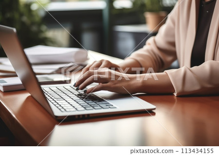 The hand of a businesswoman pressing a laptop keyboard on a table, focused on work, Ai Generated 113434155