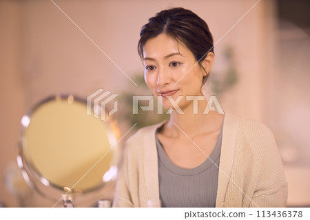 Middle-aged woman doing night skin care Middle-aged woman doing night skin care 113436378