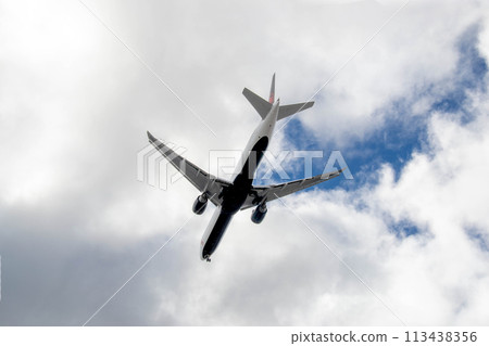 White passenger airplane flying in the sky amazing clouds in the background White passenger airplane flying in the sky amazing clouds in the background 113438356