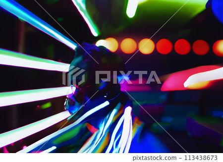 A person profiled against a vibrant backdrop of neon lights. 113438673