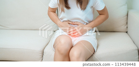 woman having abdomen ache due to Stomach pain, digestion with constipation or Diarrhea from food poisoning, female problem and Endometriosis, Hysterectomy, Stomachache and Menstrual on sofa at home 113439448