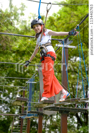adventure climbing high wire park - people on course in mountain helmet 113440763