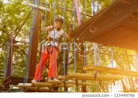 adventure climbing high wire park - people on course in mountain helmet 113440766
