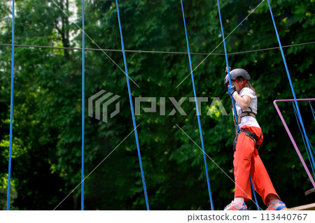 adventure climbing high wire park - people on course in mountain helmet adventure climbing high wire park - people on course in mountain helmet 113440767