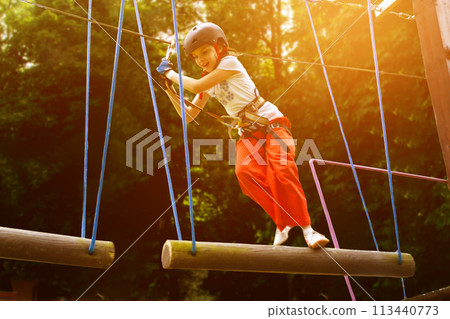 adventure climbing high wire park - people on course in mountain helmet adventure climbing high wire park - people on course in mountain helmet 113440773