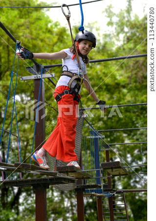 adventure climbing high wire park - people on course in mountain helmet 113440780