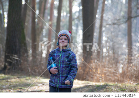 Boy spends happy time outdoors in forest enjoying autumn nature 113440834