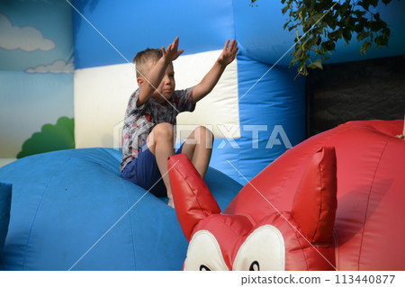 Joyful little girl playing on a trampoline. 113440877