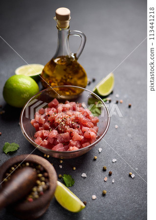 Sliced and chopped tuna fillet in glass bowl at domestic kitchen cooking traditional tartare 113441218