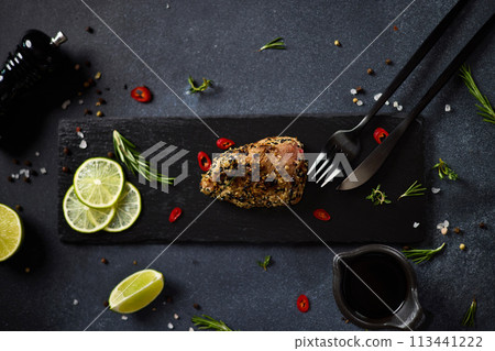 Organic grilled Tuna fillet covered with sesame seeds on black stone serving board Organic grilled Tuna fillet covered with sesame seeds on black stone serving board 113441222
