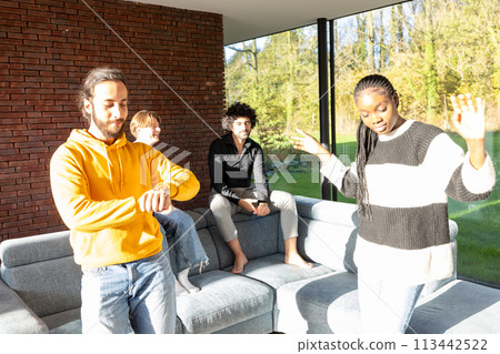 Group of Friends Enjoying a Lively Conversation in a Sunny Living Room 113442522