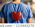 Heart surgeon seen from behind in blue coat goes for open-heart surgery in hospital ward 113443270