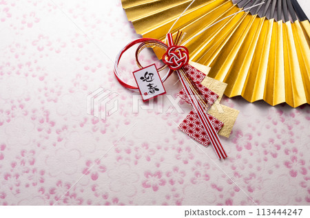 A Japanese-style image with a golden fan, New Year's decorations, and pink washi paper A Japanese-style image with a golden fan, New Year's decorations, and pink washi paper 113444247