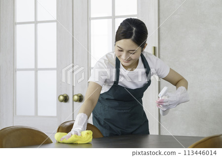 Housekeeping: Young female staff wiping the table 113446014