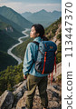 A young happy Chinese young woman with a tourist backpack stands on top of a rock in the mountains, travels and enjoys a beautiful view of the mountains, sky or nature. Untouched nature. Tourism and 113447370
