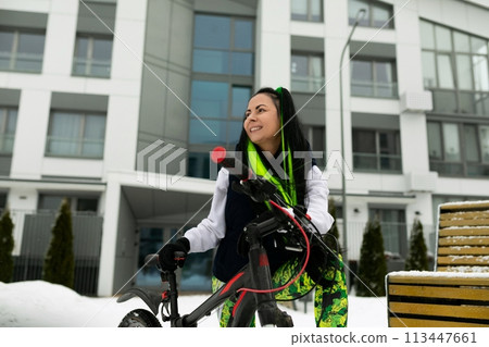 Woman Standing Next to Bike in Snow 113447661