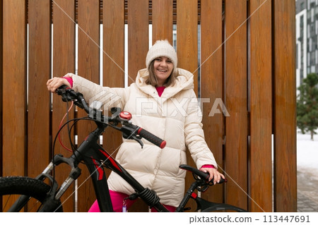 Woman Standing Next to Bike by Wooden Fence Woman Standing Next to Bike by Wooden Fence 113447691