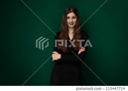 Woman Standing With Arms Crossed in Front of Green Background Woman Standing With Arms Crossed in Front of Green Background 113447714