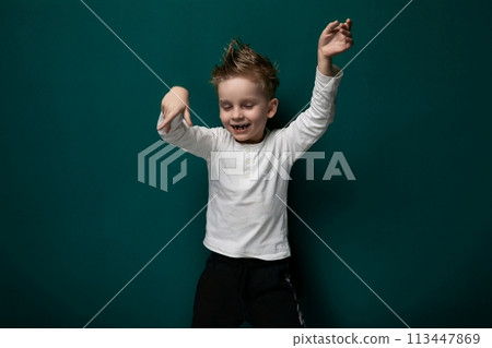 Young Boy Standing in Front of Green Wall Young Boy Standing in Front of Green Wall 113447869