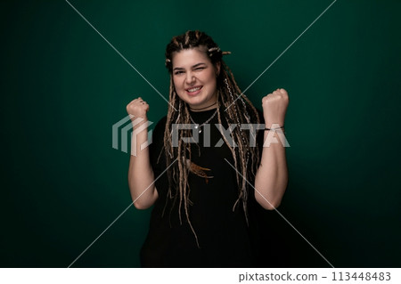 Woman With Dreadlocks Standing in Front of Green Wall 113448483