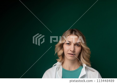 Woman Standing in Front of Green Background 113448489