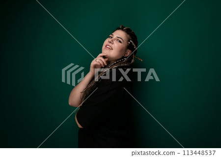 Woman Leaning Against Green Wall With Hand on Chin Woman Leaning Against Green Wall With Hand on Chin 113448537