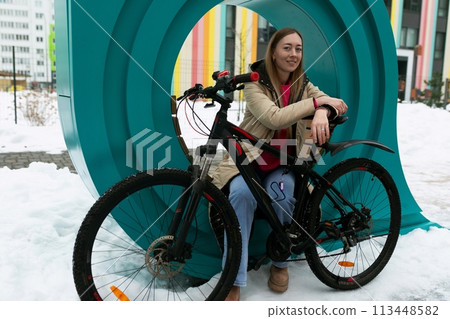 Woman Sitting on Top of Bike in Snow 113448582