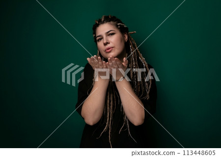 Woman With Dreadlocks Standing in Front of Green Wall 113448605
