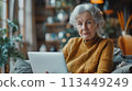Senior Businesswoman Working on Laptop in Cozy Home Environment 113449249