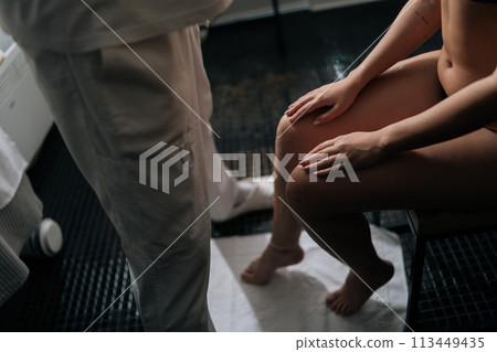 High-angle view of unrecognizable masseur male make relaxing therapeutic head massage to young woman in wellness center. Happy pretty female getting head massage by professional masseur in spa salon. 113449435