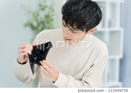 一個男人拿著錢包，裡面沒有錢 113449739