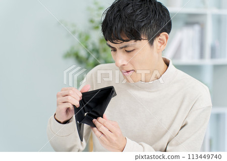 一個男人拿著錢包，裡面沒有錢 113449740