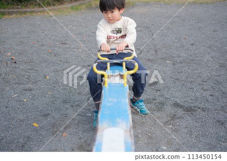 Boy playing with seesaw 113450154