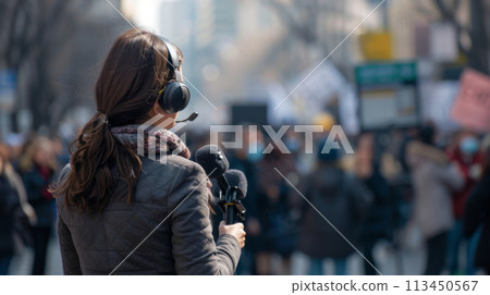 Reporter with Microphone Covering Street Protest 113450567